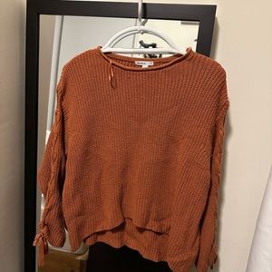 Orange knit sweater with ties on arms